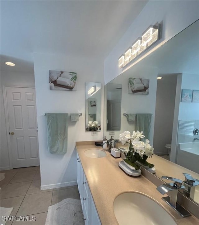 bathroom with tile patterned floors, double vanity, toilet, and a sink