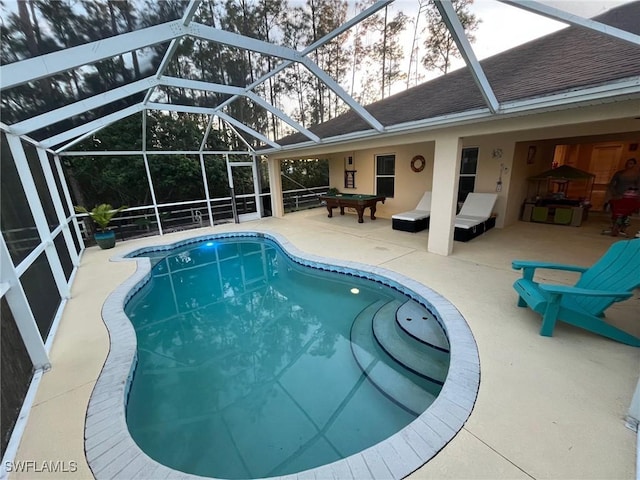 view of swimming pool featuring a patio area and glass enclosure