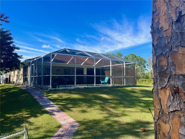 back of property featuring glass enclosure, a yard, and a pool