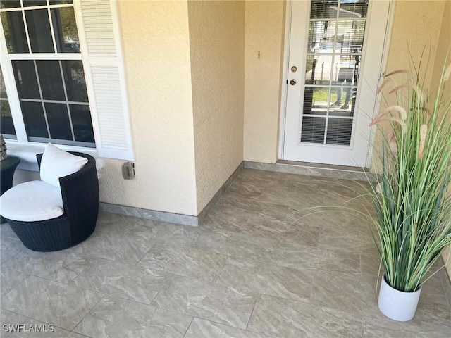 entrance to property featuring stucco siding