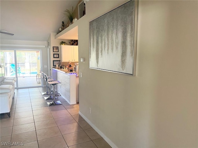 corridor with light tile patterned floors and baseboards