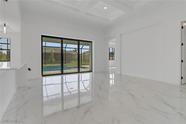 unfurnished room with coffered ceiling, a wealth of natural light, beamed ceiling, and a towering ceiling