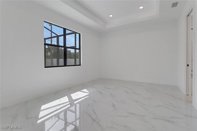 unfurnished room with a tray ceiling