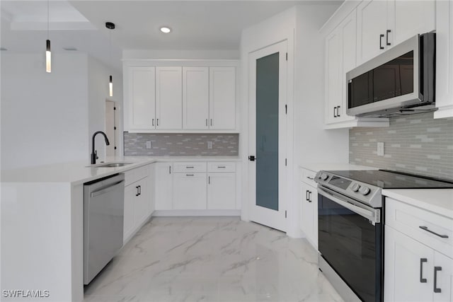 kitchen featuring appliances with stainless steel finishes, decorative light fixtures, sink, and white cabinets