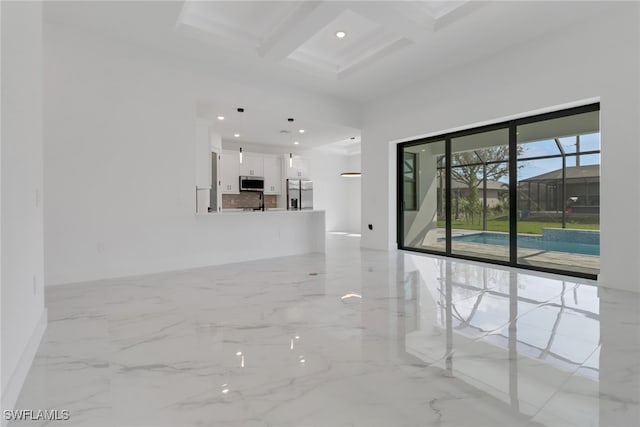 unfurnished living room featuring coffered ceiling and beam ceiling