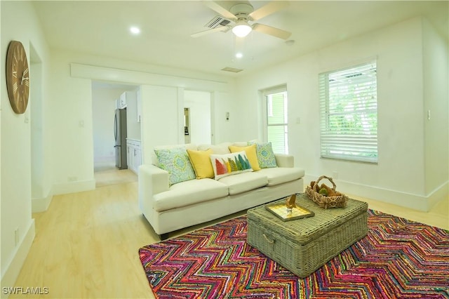 living room with ceiling fan and light wood-type flooring