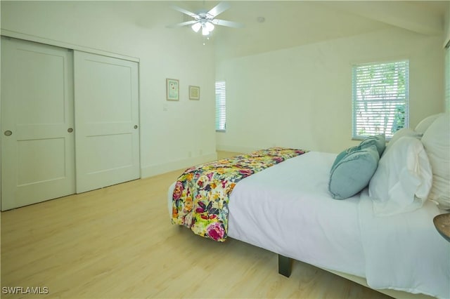 bedroom with light hardwood / wood-style flooring, a closet, and ceiling fan