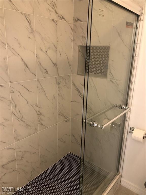 bathroom featuring a shower with shower door