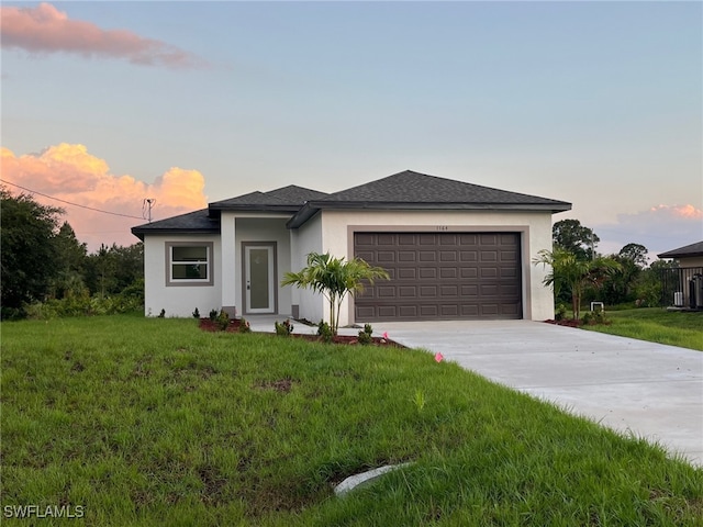 view of front of house featuring a garage and a lawn