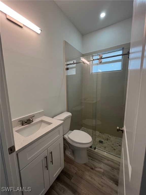 bathroom with vanity, an enclosed shower, hardwood / wood-style flooring, and toilet