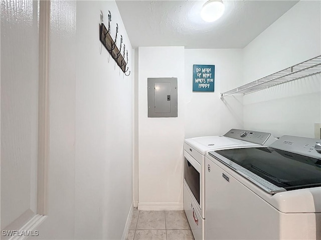 laundry area featuring light tile patterned floors, washer and clothes dryer, and electric panel