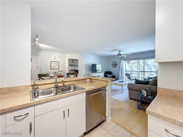 kitchen with light tile patterned flooring, sink, stainless steel dishwasher, ceiling fan, and white cabinets