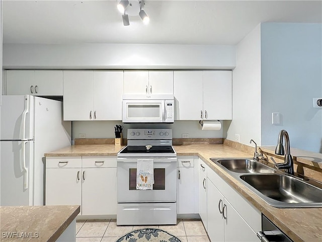 kitchen with sink, light tile patterned floors, white cabinets, and white appliances