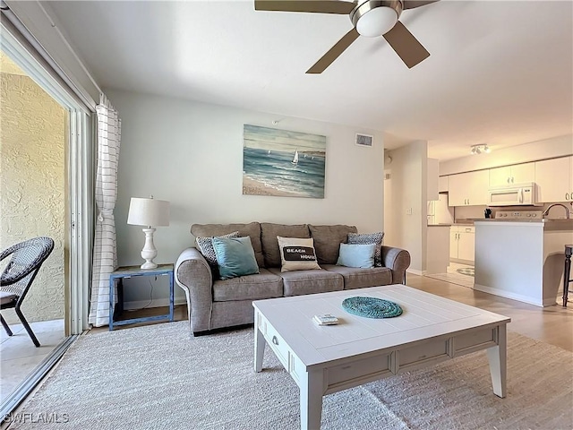 living room featuring ceiling fan and light wood-type flooring