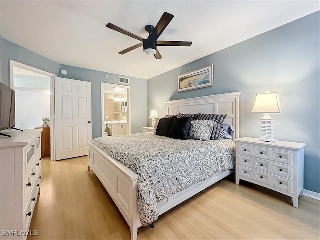 bedroom with ceiling fan, connected bathroom, and light hardwood / wood-style flooring