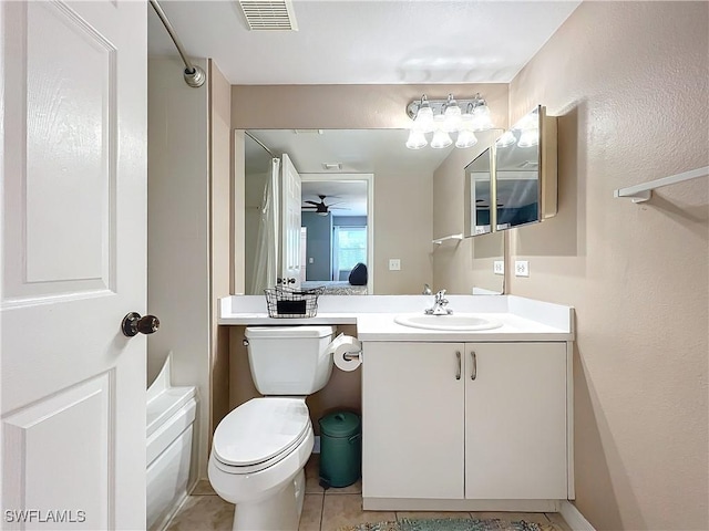 bathroom with tile patterned flooring, vanity, a tub, and toilet