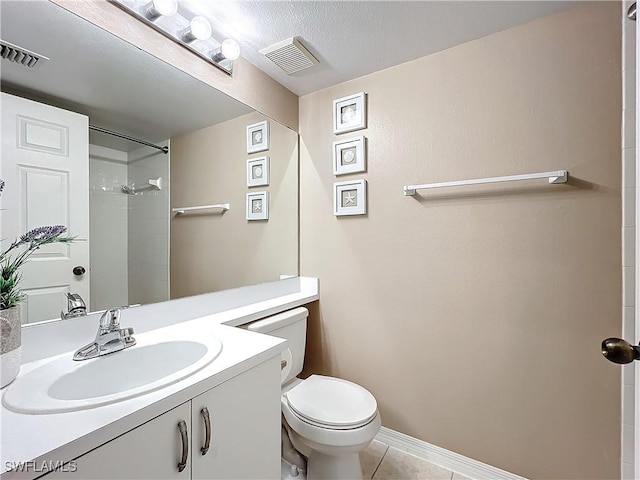 bathroom with vanity, a shower, tile patterned floors, and toilet