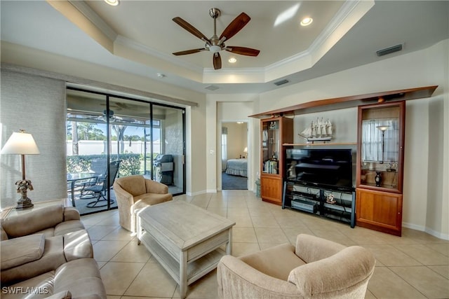 tiled living room featuring crown molding, ceiling fan, and a tray ceiling