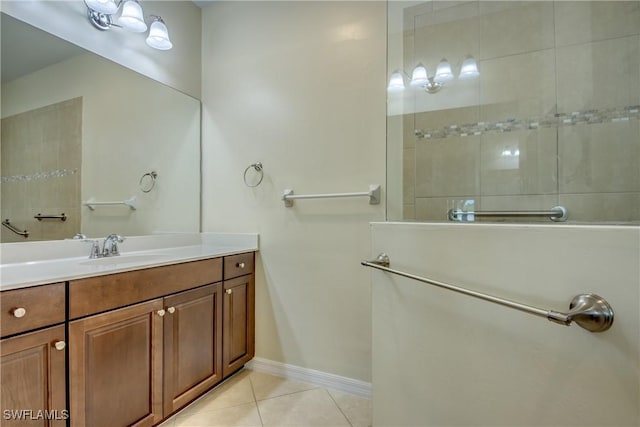 bathroom with tile patterned flooring, vanity, and tiled shower