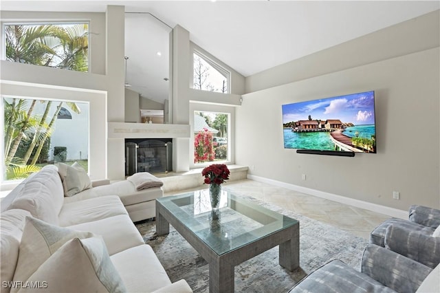 living room with a fireplace, high vaulted ceiling, and light tile patterned flooring