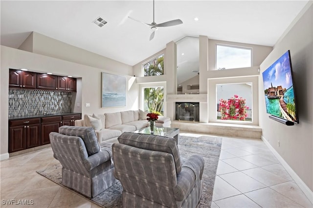 tiled living room featuring a wealth of natural light and high vaulted ceiling