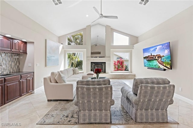 living room featuring sink, high vaulted ceiling, ceiling fan, and light tile patterned flooring