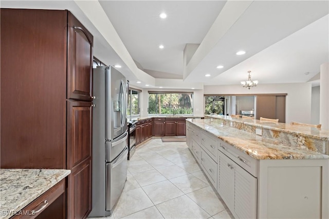 kitchen with a large island, light tile patterned floors, electric range, light stone countertops, and stainless steel fridge with ice dispenser