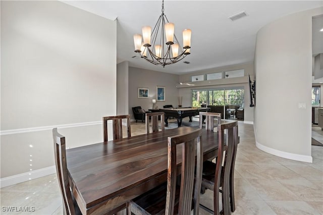 dining space with light tile patterned flooring and an inviting chandelier