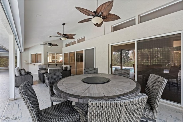 view of patio with ceiling fan and a bar