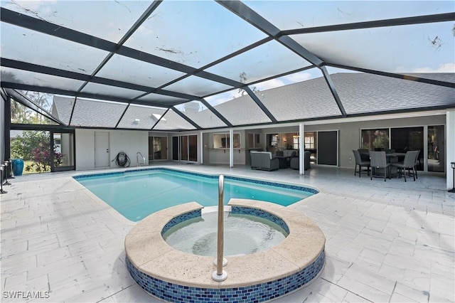 view of pool with an in ground hot tub, glass enclosure, and a patio