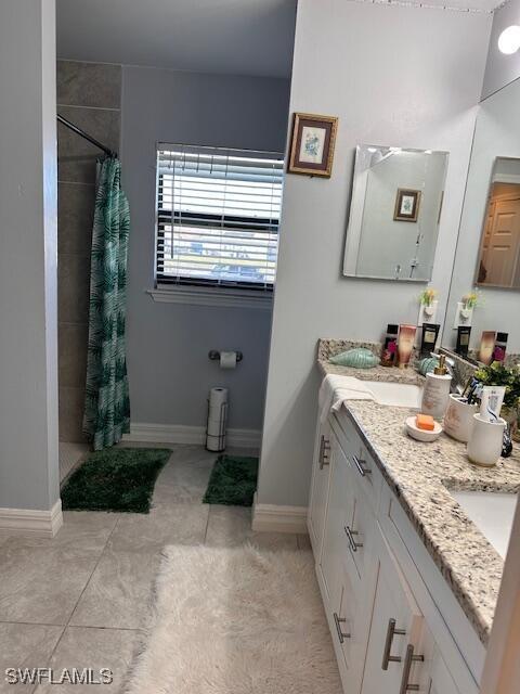 bathroom with a shower with curtain, vanity, and tile patterned flooring