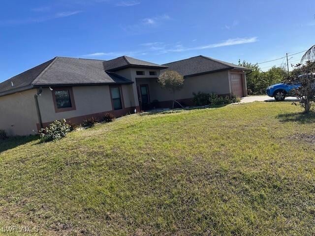 view of front of house with a garage and a front lawn