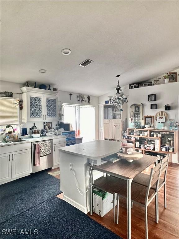 kitchen featuring sink, white cabinetry, hanging light fixtures, a kitchen island, and stainless steel dishwasher