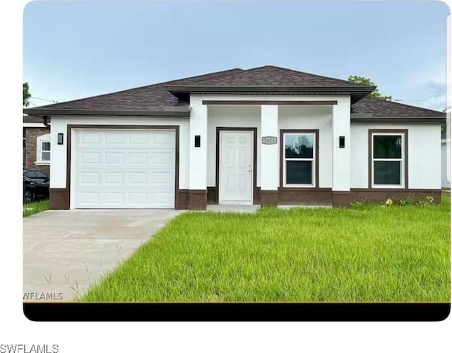 view of front of home with a garage and a front lawn