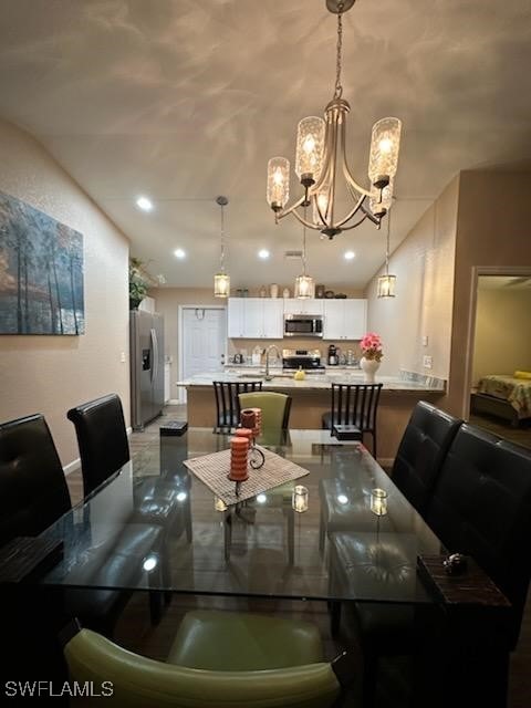 dining space featuring sink and a notable chandelier