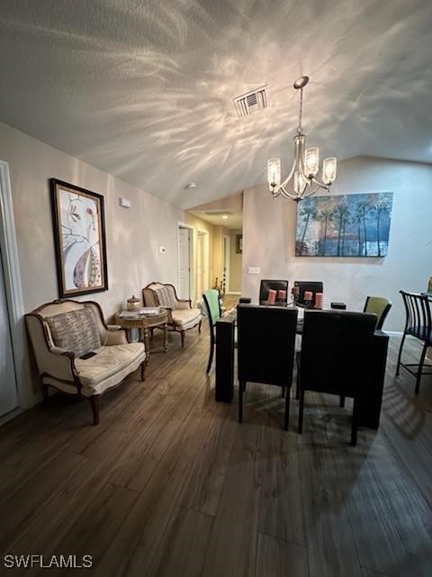 dining room featuring hardwood / wood-style flooring, vaulted ceiling, and a notable chandelier