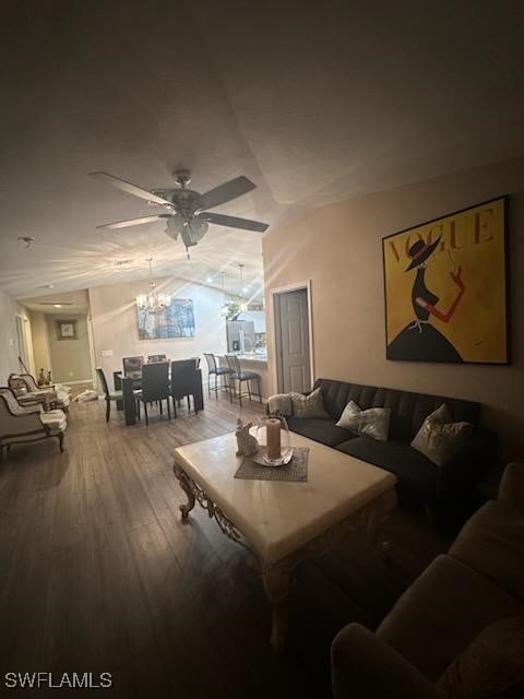 living room featuring ceiling fan with notable chandelier and wood-type flooring