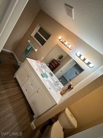 interior space featuring hardwood / wood-style flooring, vanity, and toilet