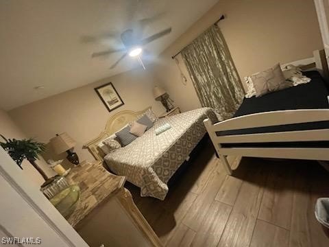 bedroom with vaulted ceiling, light hardwood / wood-style floors, and ceiling fan