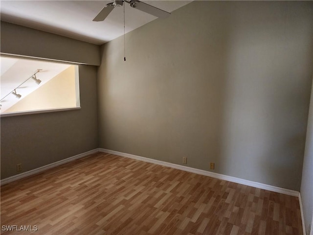 unfurnished room with rail lighting, hardwood / wood-style floors, and ceiling fan