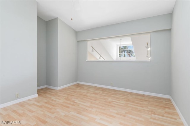 unfurnished room with light wood finished floors and baseboards