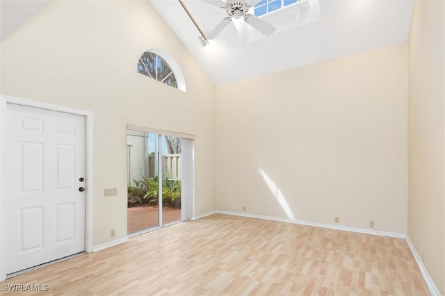 interior space with ceiling fan, high vaulted ceiling, light wood-style flooring, and baseboards