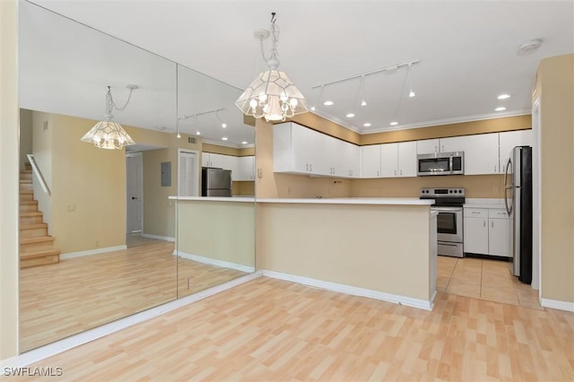 kitchen featuring white cabinets, appliances with stainless steel finishes, open floor plan, decorative light fixtures, and light countertops