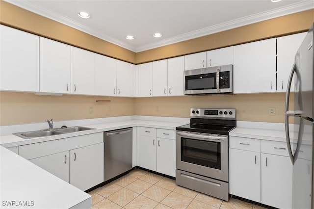 kitchen with white cabinets, appliances with stainless steel finishes, light countertops, crown molding, and a sink