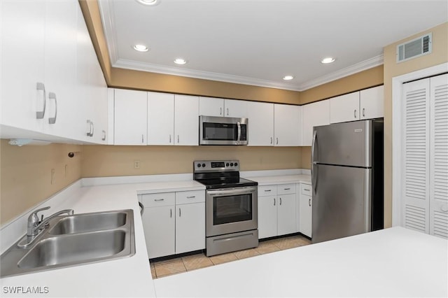 kitchen featuring stainless steel appliances, light countertops, white cabinetry, and a sink