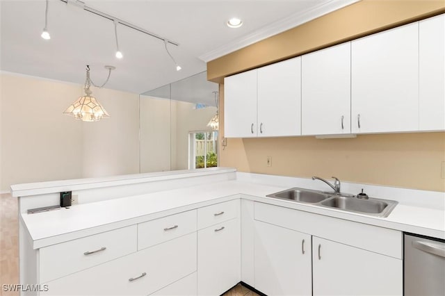 kitchen with white cabinets, pendant lighting, light countertops, and a sink