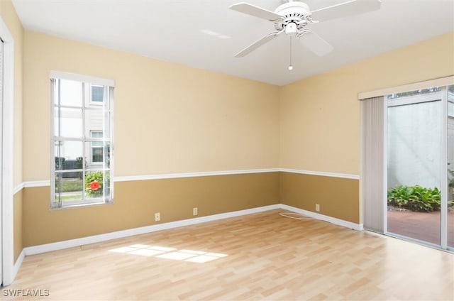 spare room featuring ceiling fan, light wood-type flooring, and baseboards