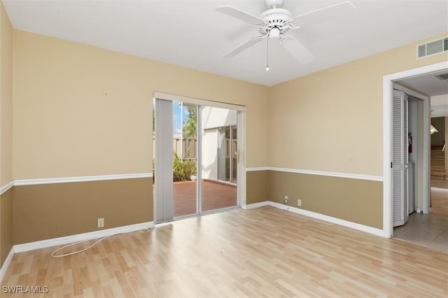 empty room featuring light wood-type flooring, visible vents, ceiling fan, and baseboards