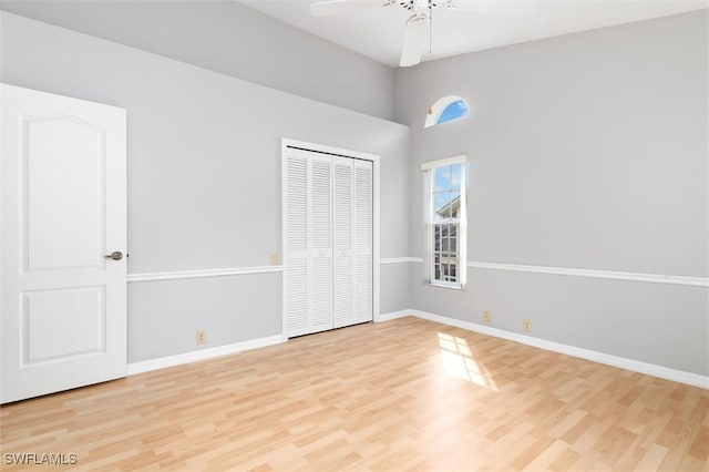 unfurnished bedroom with a ceiling fan, light wood-type flooring, a closet, and baseboards