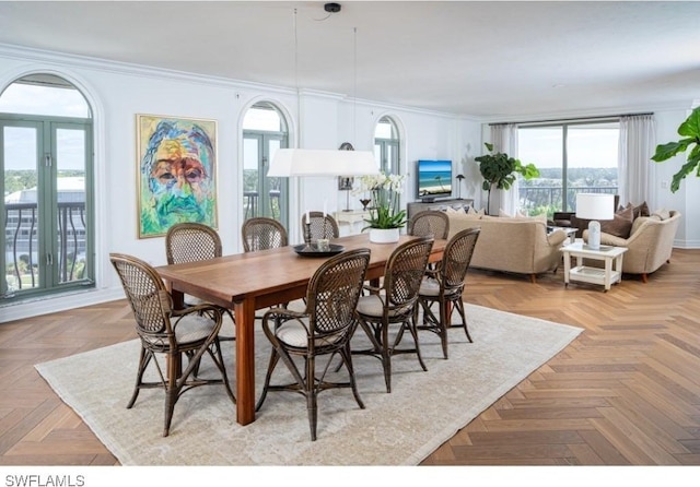 dining space with light parquet floors and crown molding